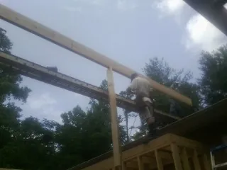 Carpenter setting a ridge beam over a new addition frame — Ice Dam Removal by Roofing Brothers in Frankenmuth