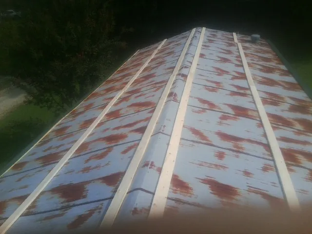 Rusted metal roof panels with new wood purlins before replacement — Storm Damage Roof Repair in Frankenmuth by Roofing Brothers
