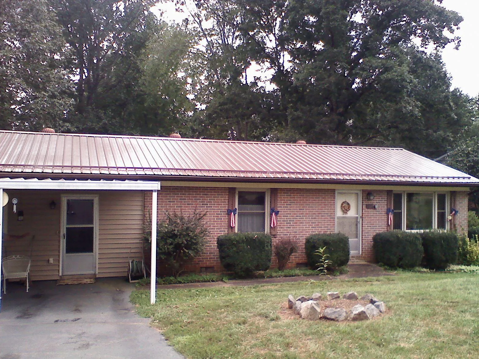 Bronze metal roof and carport on a brick ranch home — Roof Repair work by our crew in Frankenmuth